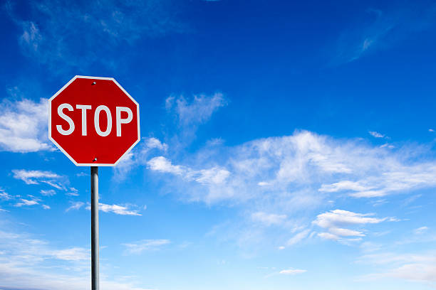 stop-sign-with-blue-sky-background-and-copy-space-picture-id517346408